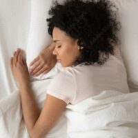 Femme de 35 ans dormant en toute sérénité grâce à ses bouchons auditifs moulés sur mesure